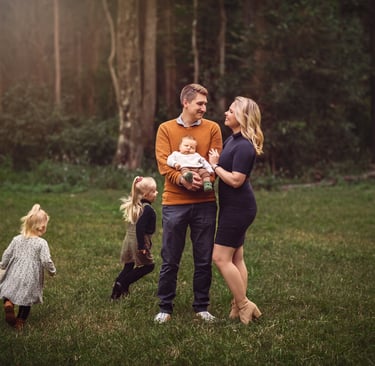 a family of three children and a baby in a field