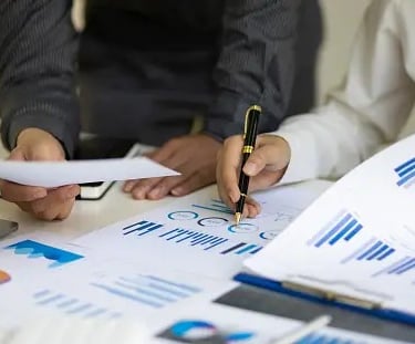 a group of people sitting at a table with papers and papers