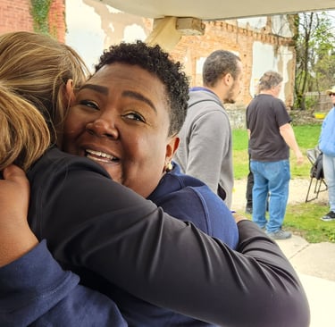 a woman in a blue jacket is hugging a man