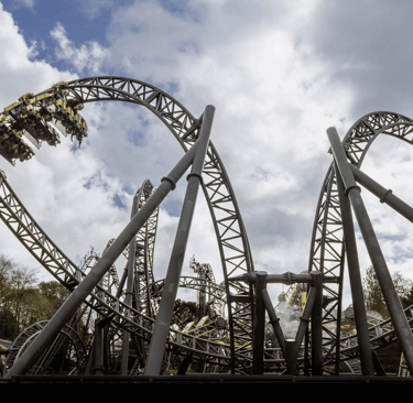 A Roller coaster in the shape of eyes and a smile with a cart on a loop to the left