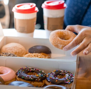 person taking donut from To Go box