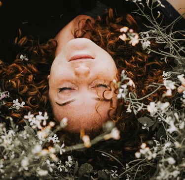 woman lying in a pile of flowers
