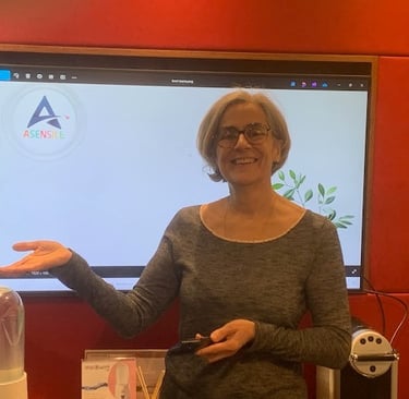 Une femme professionnelle souriante faisant une présentation avec le logo ASENSILE à l'écran