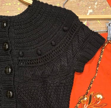 a black sweatered cardigand sweater with a handmade knitted cardigan