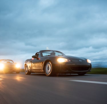 two cars driving on a highway with headlights on