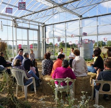 Une foule est assise dans une serre et écoute la conférence sur Vivant et Vivants de la FDW