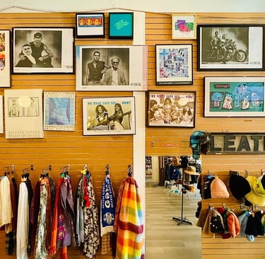 photo from inside Magpie Thrift Capitol Hill showing scarves and hats under framed pride photos