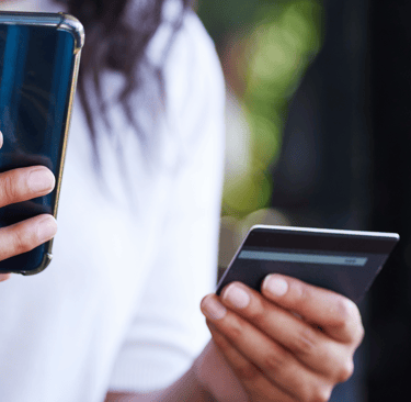 Woman holding cell phone and credit card