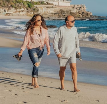Pareja de jubildados caminando por la Playa al migrar a España