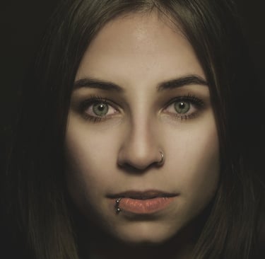 a woman with piercings on her nose and lip, green eyes