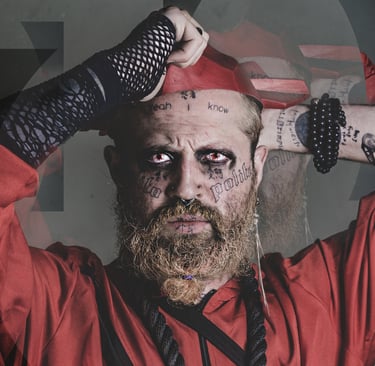 a man with a red costume, face tattoos, a beard