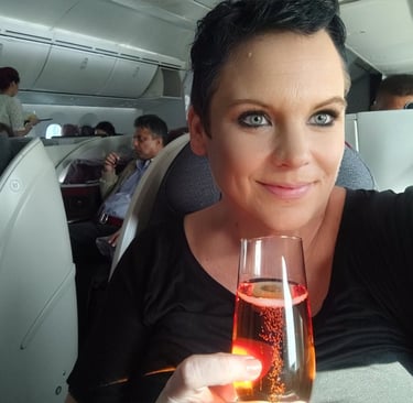 a woman holding a glass of wine in a plane