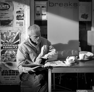 Man reading paper whilst drinking coffee - Peter Pickering Street Photography