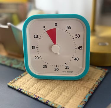 small visual timer set to 5 minutes sitting on a desk