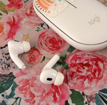 airpods next to a computer mouse on a rose print mousepad