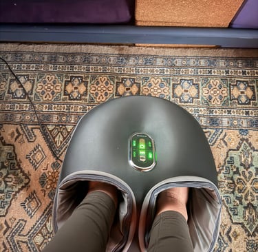 an electronic foot massager with feet inside and glowing green power lights