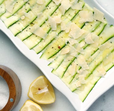 Un plato rectangular blanco con un carpaccio de calabacín