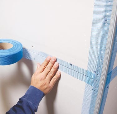 a person holding a tape tape and tape tape on a wall