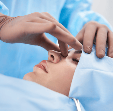 Surgeon performing a rhinoplasty procedure on a patient in a medical clinic for nose reshaping surgery.