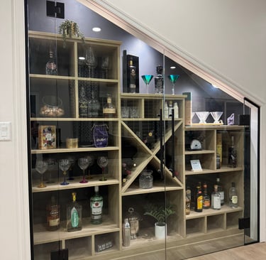 Wine and liquor wall, custom cabinets from California Closets. Under stair storage