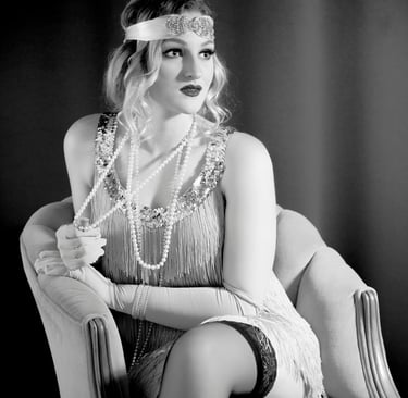 Attractive blonde female wearing classic flapper beaded dress, long strands of pearls and headband