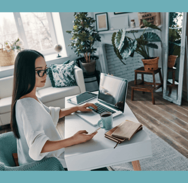 Female working from home with laptop in beautiful calm environment.