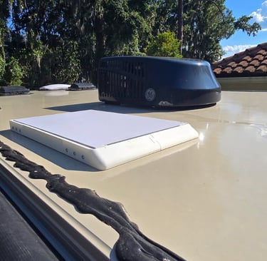 RV roof showing a vent and a Starlink mini dish..