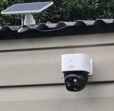 Solar powered wireless outdoor security camera mounted on a residential wall for home surveillance.