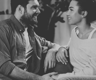 "Couple assis, discutant calmement et consciemment dans leur salon, l'un exprimant un besoin, l'autr