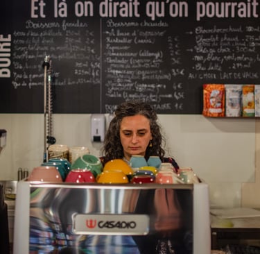 Barista dans son coffee shop qui prépare un latte avec du lait végétal