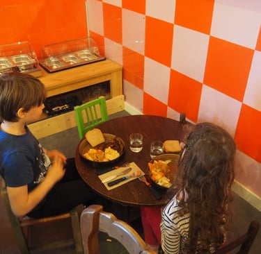 Enfants qui mangent en autonomie à table à côté du self-sevice enfant 