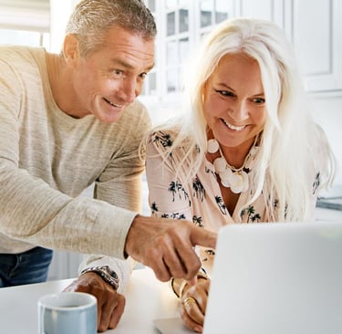 a man and woman looking at a laptop computer