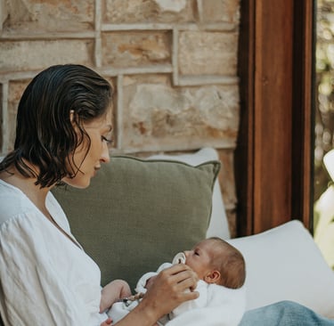 natural, lifestyle newborn photograph of mom looking down at baby