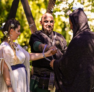 Ceremonia de boda al aire libre con pareja vestida al estilo medieval, atados por una cuerda mientra
