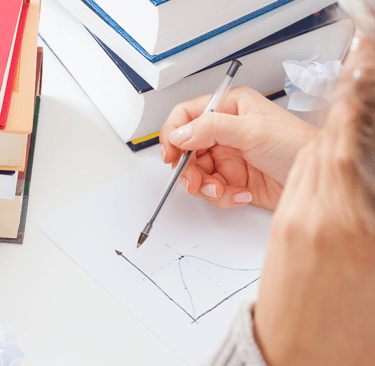 a woman is sitting at a desk with a pencil and pencil