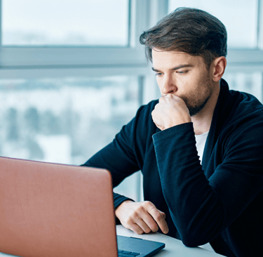 a man sitting at a table with a laptop computer