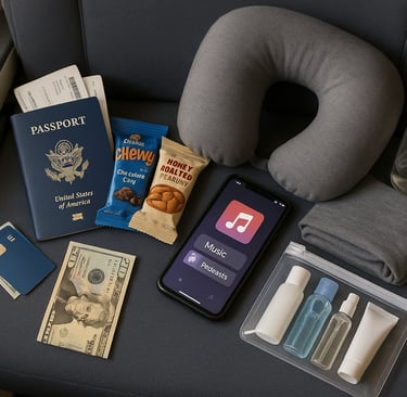 Flat lay of carry-on travel essentials including passport, snacks, travel pillow, empty water bottle, phone with entertainmen