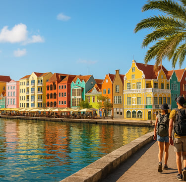 Colorful waterfront buildings in Willemstad, Curaçao with two backpackers walking along a palm-lined promenade beside calm tu