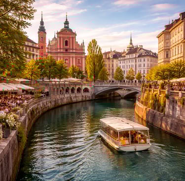 Ljubljana’s Ljubljanica River at sunset with riverside cafés, pastel old town buildings, bridges, and a riverboat cruise