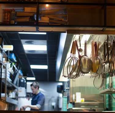 A busy restaurant owner in the kitchen who doesn't have time to keep up with everything.