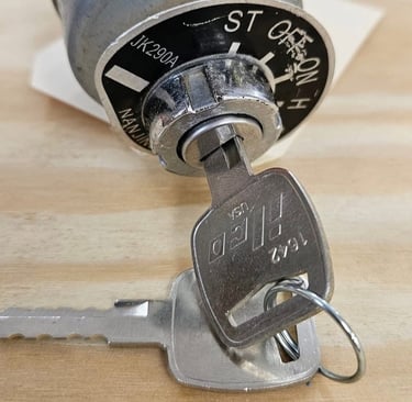 Car ignition switch and key during ignition repair on workbench.