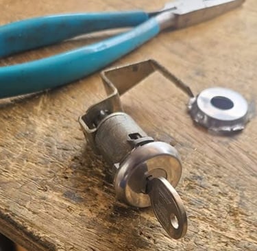 Car ignition cylinder repair by Jack’s Locksmith in Marion NC with key inserted and tools on workbench.