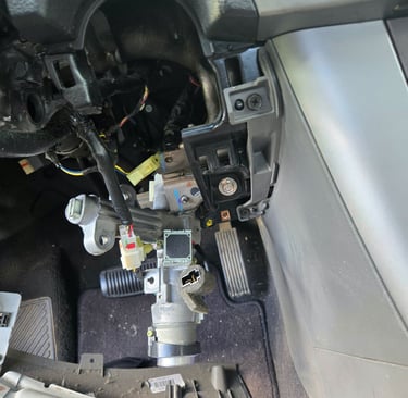 Car ignition cylinder exposed with steering column trim removed