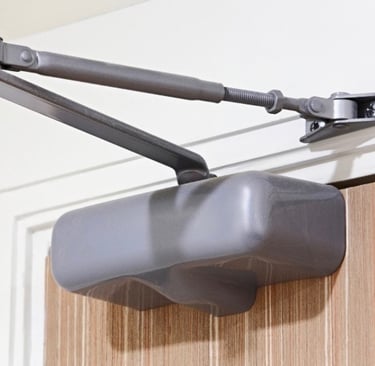 A close-up of a door closer representing Jack’s Locksmith reliable door closer services in Boone, NC