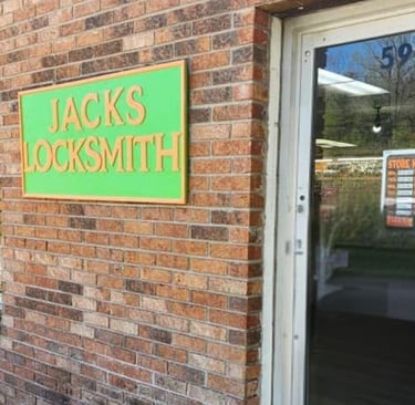 Green and orange "Jack's Locksmith" storefront sign in Burnsville, North Carolina
