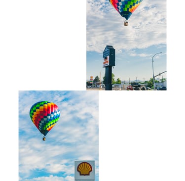A colorful rainbow checkered hot air balloon floats in a blue sky above a Shell gas station sign.
