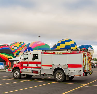 Vernal City Fire Department truck parked near colorful hot air balloons at a local community festival.