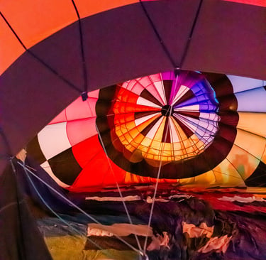 Interior view of a colorful hot air balloon being inflated with vibrant red, orange, and blue panels.