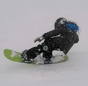 un bambino esegue un tail press con lo snowboard