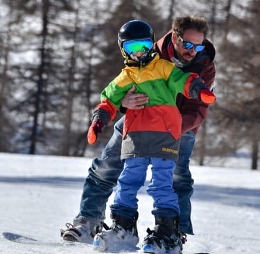Bambino durante una lezione di snowboard a Sestriere con il maestro